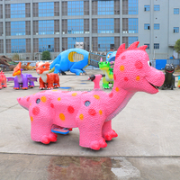 Les filles montent sur le scooter rose de dinosaure pour des taches d'enfants