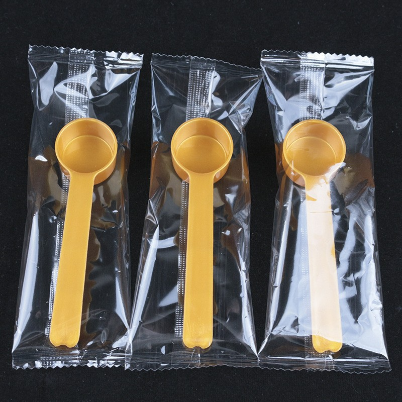 Cuillère doseuse de 4g, couleur or, emballée individuellement.