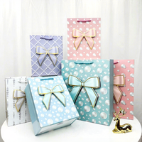 Elegante 3D-geprägte Geschenktüten aus dickem Kraftpapier mit Schleifen- und Perlenmuster, mit Griffen, in verschiedenen Farben für Boutique-Einzelhandelsverpackungen