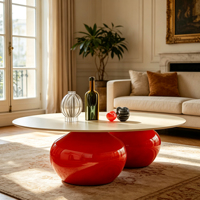 Table basse ovale en fibre de verre avec plateau crème mat et base rouge brillante à double sphère pour un espace de vie moderne haut de gamme