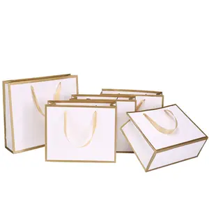 Vente en gros Sacs cadeaux de luxe en noir et blanc avec logo en feuille d'or et logo personnalisé Sac cadeau en carton à provisions en papier avec poignées en ruban