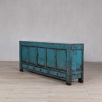 Armoire de rangement en bois massif vieilli et patiné pour un salon de style rétro et vintage, meuble de présentation pour maison d'hôtes.