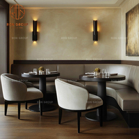 Ensemble de mobilier de café-restaurant : canapé banquette incurvé en velours beige, tables rondes en bois et chaises à assise en tissu pour café