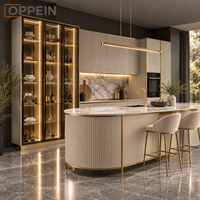 Îlot de cuisine moderne et luxueux sur mesure OPPEIN, armoire à panneaux cannelés beige avec éclairage LED pour projet de villa