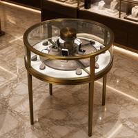 Vitrine de présentation de bijoux en laiton rond avec plateau rotatif intérieur, vitrine en verre trempé, quatre pieds, comptoir de bijouterie