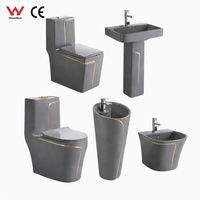 Ensemble complet de sanitaires de salle de bain en céramique gris de luxe avec ligne dorée, comprenant WC monobloc, lavabo sur colonne et bidet