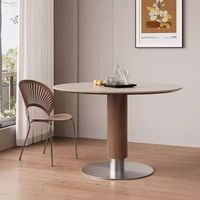 Table moderne avec plateau en pierre frittée, colonne en placage de bois et base en métal poli