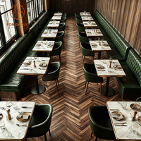 Ensemble de mobilier moderne pour café-restaurant : Table et chaises en pierre frittée verte, banquette en cuir vert en forme de L, et canapé banquette.