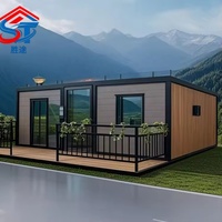 Maison conteneur modulaire extensible et amovible en panneaux sandwich gris, avec grandes fenêtres, pour retraite en montagne et usage hôtelier