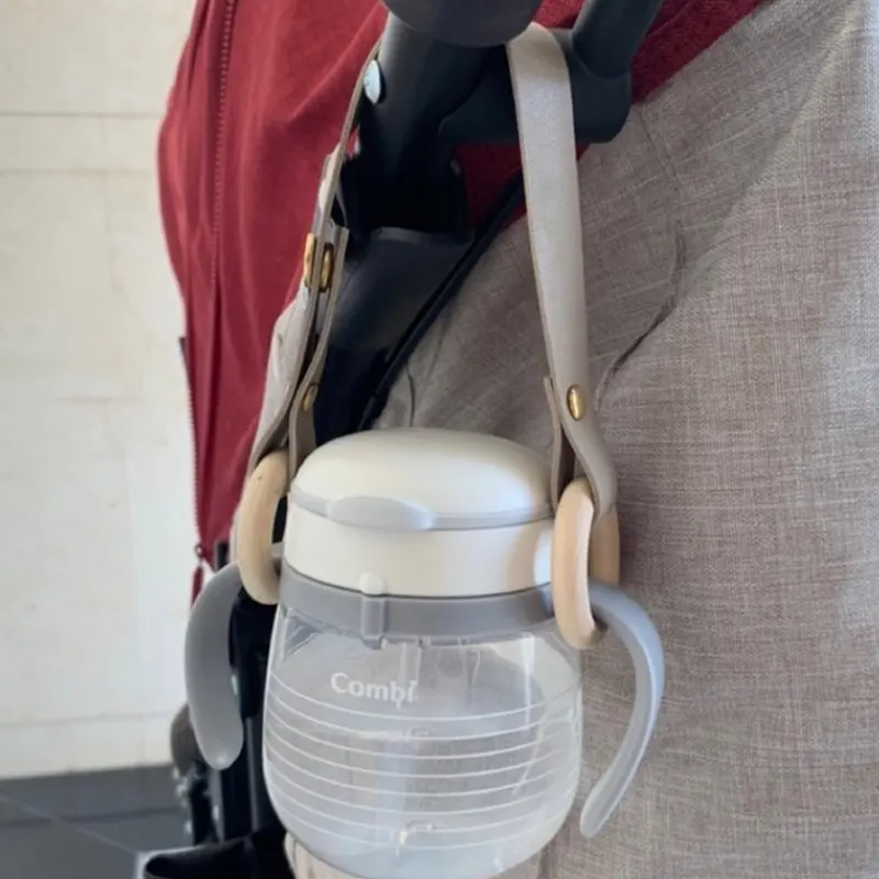 Baby-Fütterungsflasche Becherhalter tragbar Kunstleder Nursing-Flasche Stroller-Häkel Baby-Schuh-Bekleidung-Clip Babyzubehör