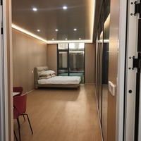 Cabane de jardin préfabriquée personnalisable avec mur à lattes verticales et grande porte vitrée pour projet de conception d'atelier à domicile