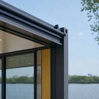 Maison conteneur préfabriquée compacte avec façade moderne, terrasse et aménagement jardiné