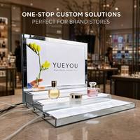 Présentoir à parfums moderne de luxe en acrylique à LED multi-niveaux, cadre en métal argenté, panneau arrière personnalisé à motif floral