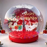 Globe de neige gonflable géant transparent pour Noël, avec fond personnalisé et base rouge, idéal pour l'affichage en centre commercial, la location pour événements et la décoration de fêtes