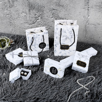 Boîte cadeau personnalisée avec logo, base et couvercle en papier mat, dessus et dessous en carton, et doublure en mousse. Boîte à bijoux découpée au laser