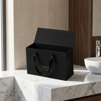 Sac cadeau de luxe noir en papier ondulé magnétique avec poignée en ruban satiné et design de logo CMYK