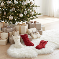 En gros, petits chaussons de Noël rouges et ivoire, ornements tricotés classiques pour bonbons et cadeaux d'enfants