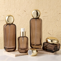 Ensemble de flacons de soin en verre ambré transparent avec pompe et pots à couvercle en aluminium doré, disponibles en 30ml, 50ml, 100ml, 120ml, 30g, 50g, pour crème
