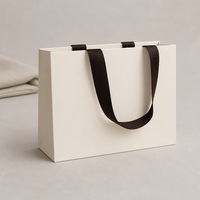 Sac cadeau en papier mat blanc crème avec poignées en ruban gros-grain brun foncé, soufflets latéraux, fond plat, impression personnalisée, vente au détail et en gros