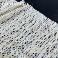 Tissu en dentelle crochetée abstrait à motif vague blanc crème, maille transparente pour robes et hauts