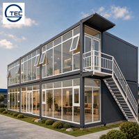 Bâtiment modulaire préfabriqué en conteneurs à deux étages avec mur-rideau entièrement vitré, porte double vitrée et escalier extérieur pour bureaux et hôpitaux