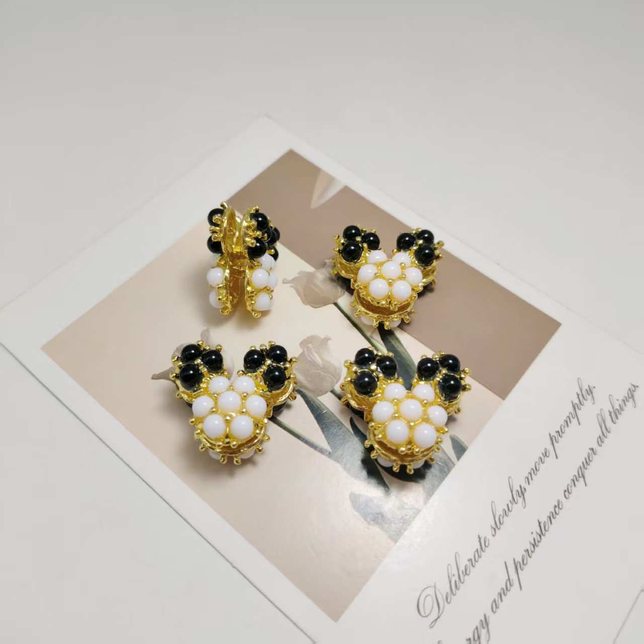 Oreilles en perles noires dorées et visage en perles blanches