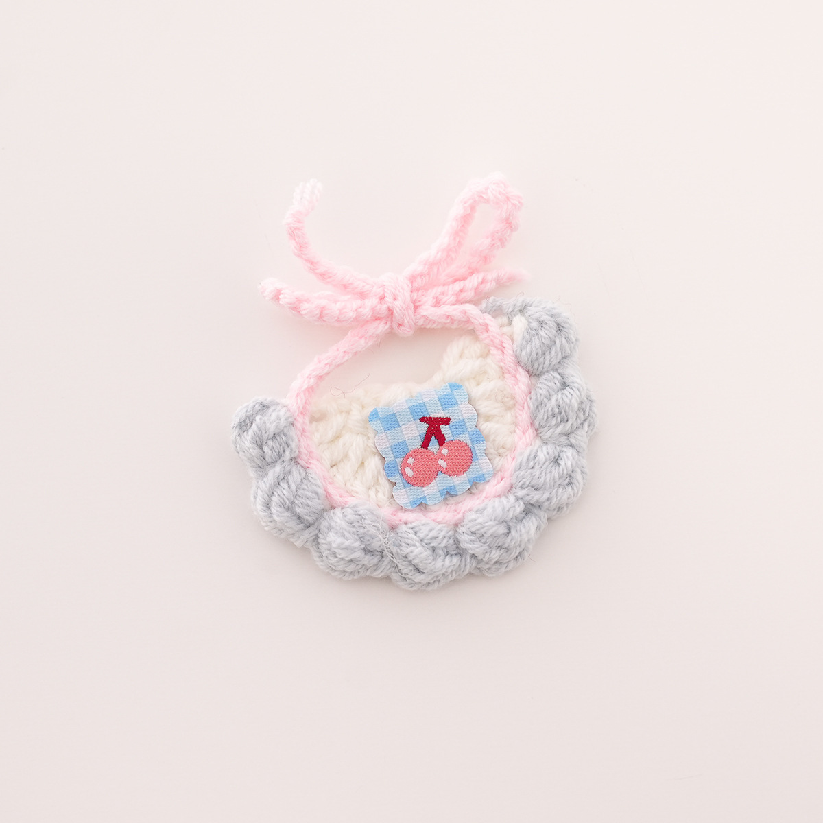 Bavoir à fond blanc, bordure bleue et cerise bleue