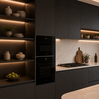 Meubles de cuisine laqués en anthracite foncé avec îlot incurvé et niches éclairées chaleureusement illuminées
