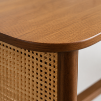 Table à manger en bois avec panneaux tressés style cannage, base à pieds ouverts et plateau arrondi pour salle à manger
