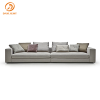Canapé blanc moderne à profil bas, sectionnel en cuir minimaliste avec accoudoirs carrés et base au sol, idéal pour appartement de luxe en immeuble de grande hauteur