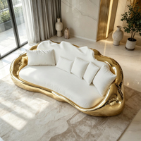 Canapé incurvé en fibre de verre moulé intégré, base en forme de vague dorée brillante, coussins décoratifs blancs assortis, canapé lounge moderne haut de gamme