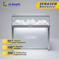 Vitrine en verre verrouillable avec comptoir en aluminium argenté, étagères réglables et portes coulissantes pour la vente au détail sécurisée