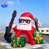 Arche gonflable géante Père Noël rockeur avec guitare, microphone et boîtes cadeaux pour l'entrée de centre commercial, la cour ou les événements de Noël