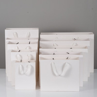 Sac en papier couché style simple avec corde pour vêtements, cadeaux, emballage de produits de luxe avec logo de marque imprimé sur mesure et carton satiné MC