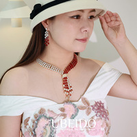 Ensemble collier et boucles d'oreilles en zircone vert émeraude, plaqué or, avec nœud croisé et franges asymétriques multi-rangs