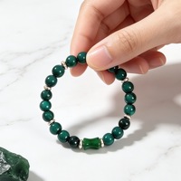 Bracelet de luxe en perles rondes de huit millimètres couleur émeraude, avec centre en forme de baril et entretoises dorées, en jade vert