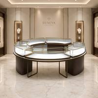 Ensemble complet de mobilier sur mesure pour bijouterie haut de gamme : îlot central combiné, comptoir de présentation et vitrine murale verticale pour colliers