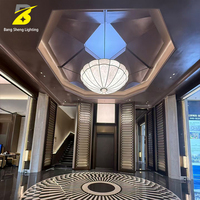 Suspension luminaire en albâtre façonné avec cadre en métal bronze foncé et abat-jour en pierre naturelle veinée pour hall d'hôtel et cave à vin