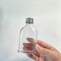 Botella plana de vidrio con logotipo personalizado de 200ml en forma de cilindro con tapa de rosca para envasar café frío o agua en estado vacío