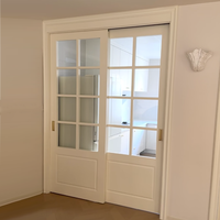 Porte intérieure coulissante moderne en polymère français, avec grille en MDF sur mesure, isolation acoustique et vitrage simple pour cour.
