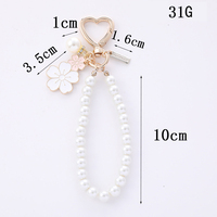 Nouveau porte-clés pendentif en alliage bicolore avec petite fleur blanche, accessoires perles et lettres, pour coque d'écouteurs et sac
