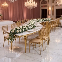 Table à manger de luxe moderne en forme de S avec pieds dorés, structure en acier inoxydable et plateau en marbre pour hôtels et mariages