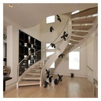 Escalier courbé sur mesure Prima Custom Home avec marches en bois massif lumineuses et structure en acier durable pour une rénovation moderne