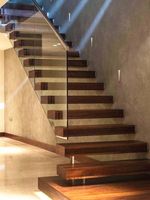 Escalier flottant droit, escalier intérieur, escalier dans le salon, la cuisine d'une maison préfabriquée avec rampes et éclairage