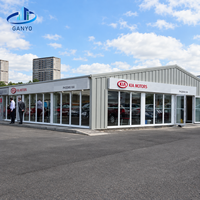 Bâtiment d'exposition automobile en structure métallique avec façade vitrée et toit à pente basse pour un espace d'exposition de véhicules sur un seul étage