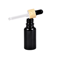 Flacon compte-gouttes cylindrique en verre noir mat personnalisé avec logo, bouchon doré/noir, pour huiles essentielles, sérums et cosmétiques – Vente en gros