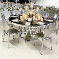 Table de salle à manger ronde de luxe avec plateau en verre noir, base géométrique argentée et structure en acier inoxydable