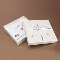 Caja de regalo de joyería de Navidad pequeña directa de fábrica Paquete de joyería 2023 con nodo Debossed logo cinta Lazo y esponja