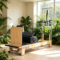 Reformador de Pilates de doble uso de roble con media torre y tabla de salto para sesiones de entrenamiento en pareja y fitness en sala