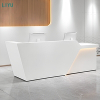 Bureau d'accueil moderne avec panneau géométrique à facettes et éclairage LED pour hall d'entreprise ou comptoir d'accueil